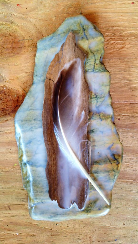 Feather and wood on stone